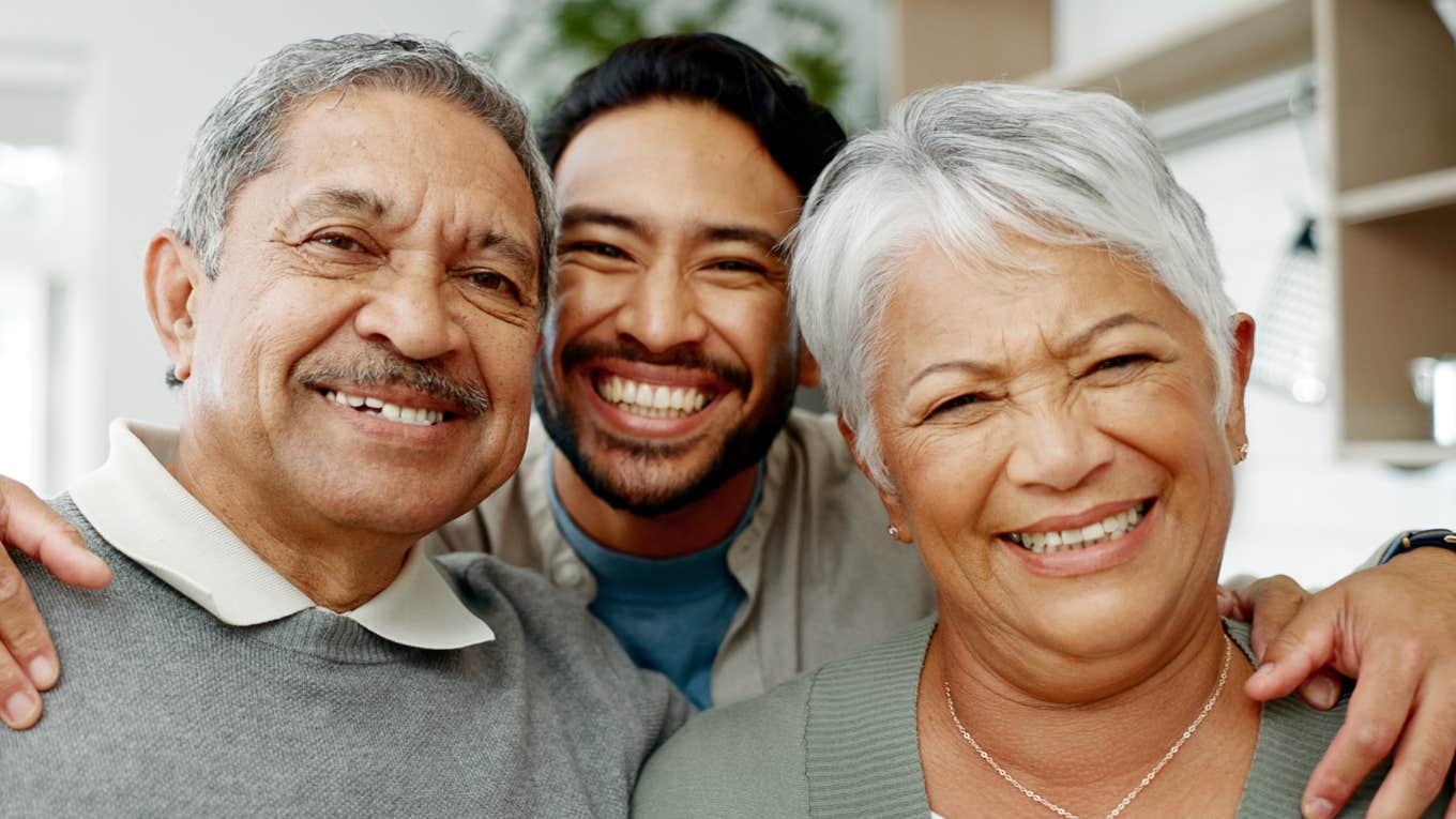 Portrait, hug and adult son with parents