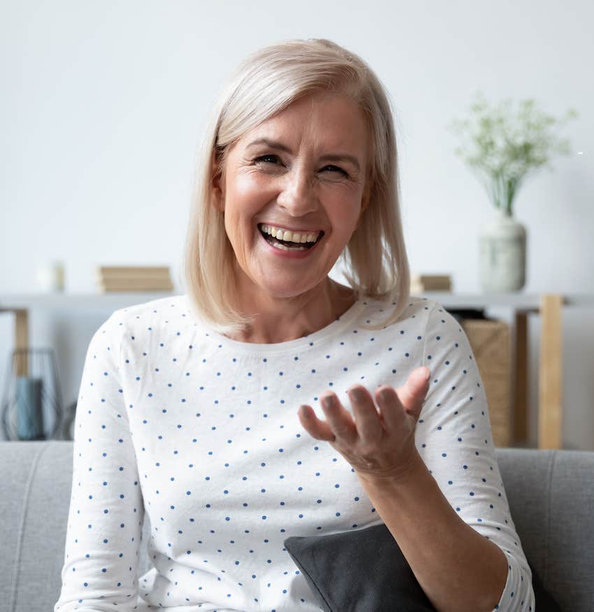 Smilng woman gestures positively with hand