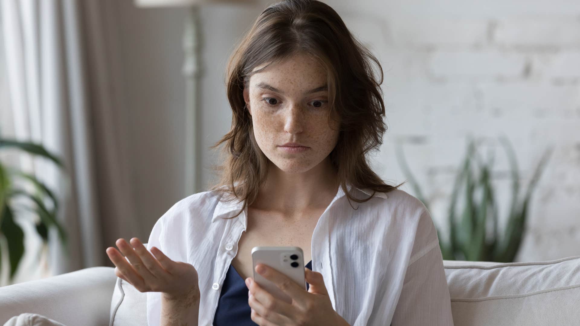 upset jealous woman looking at her phone