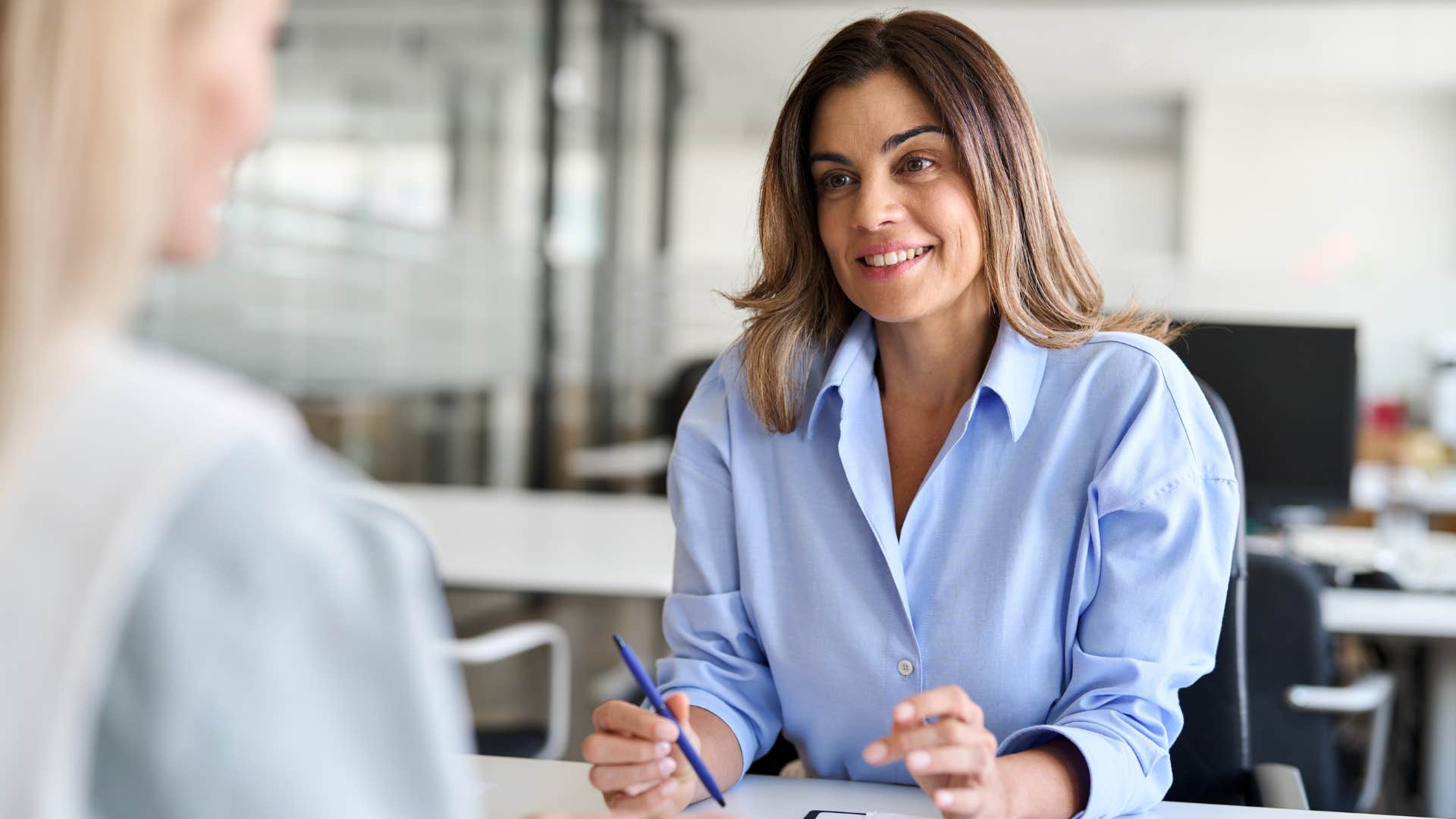 professional woman smiling and talking to a peer