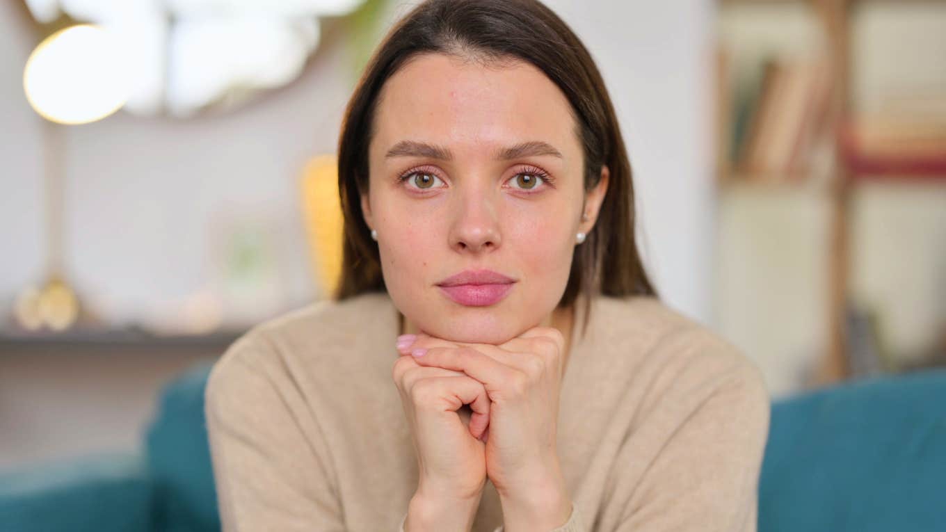 young self-aware woman with hands on her chin