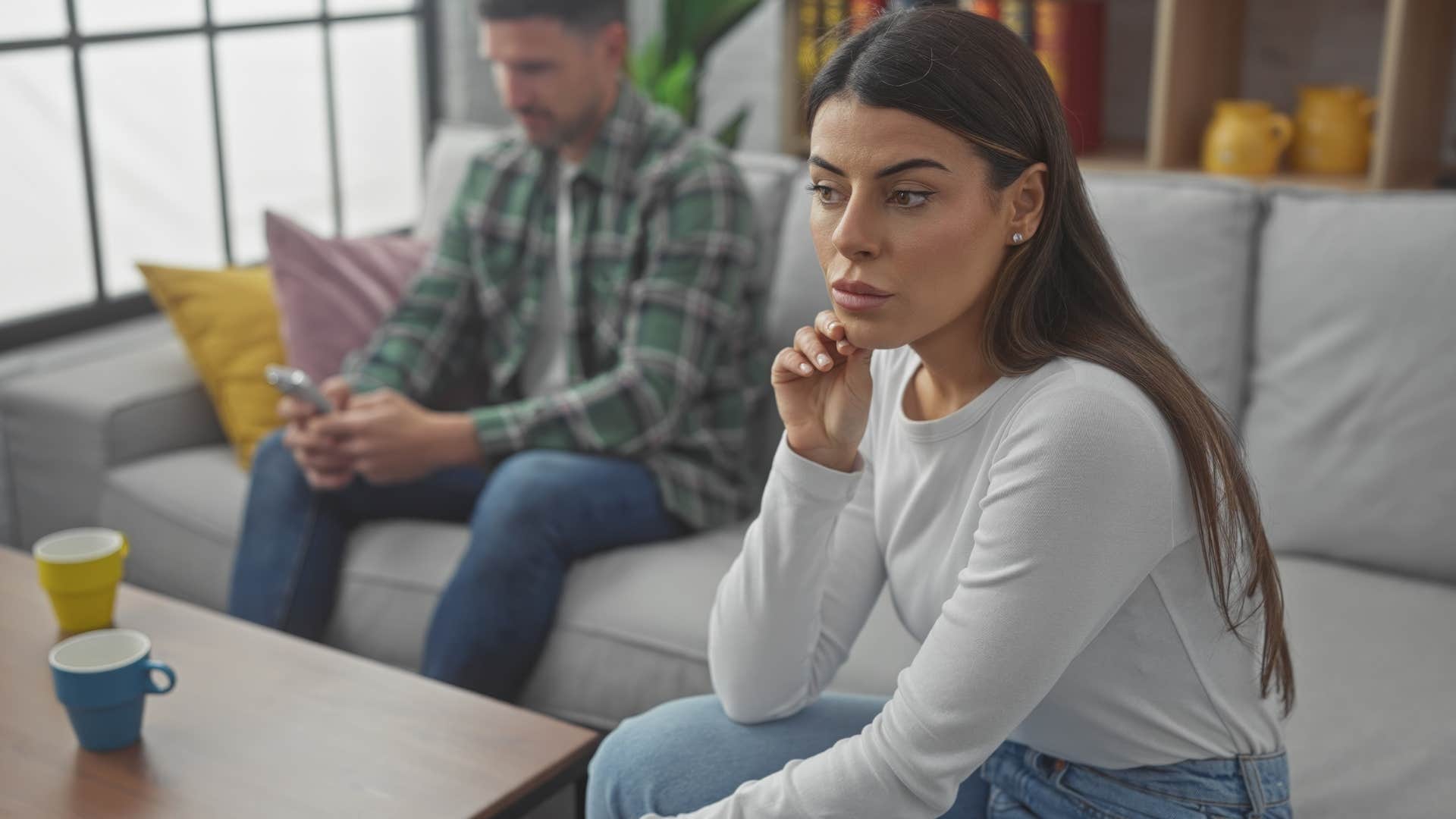 nervous woman turned away from distracted man