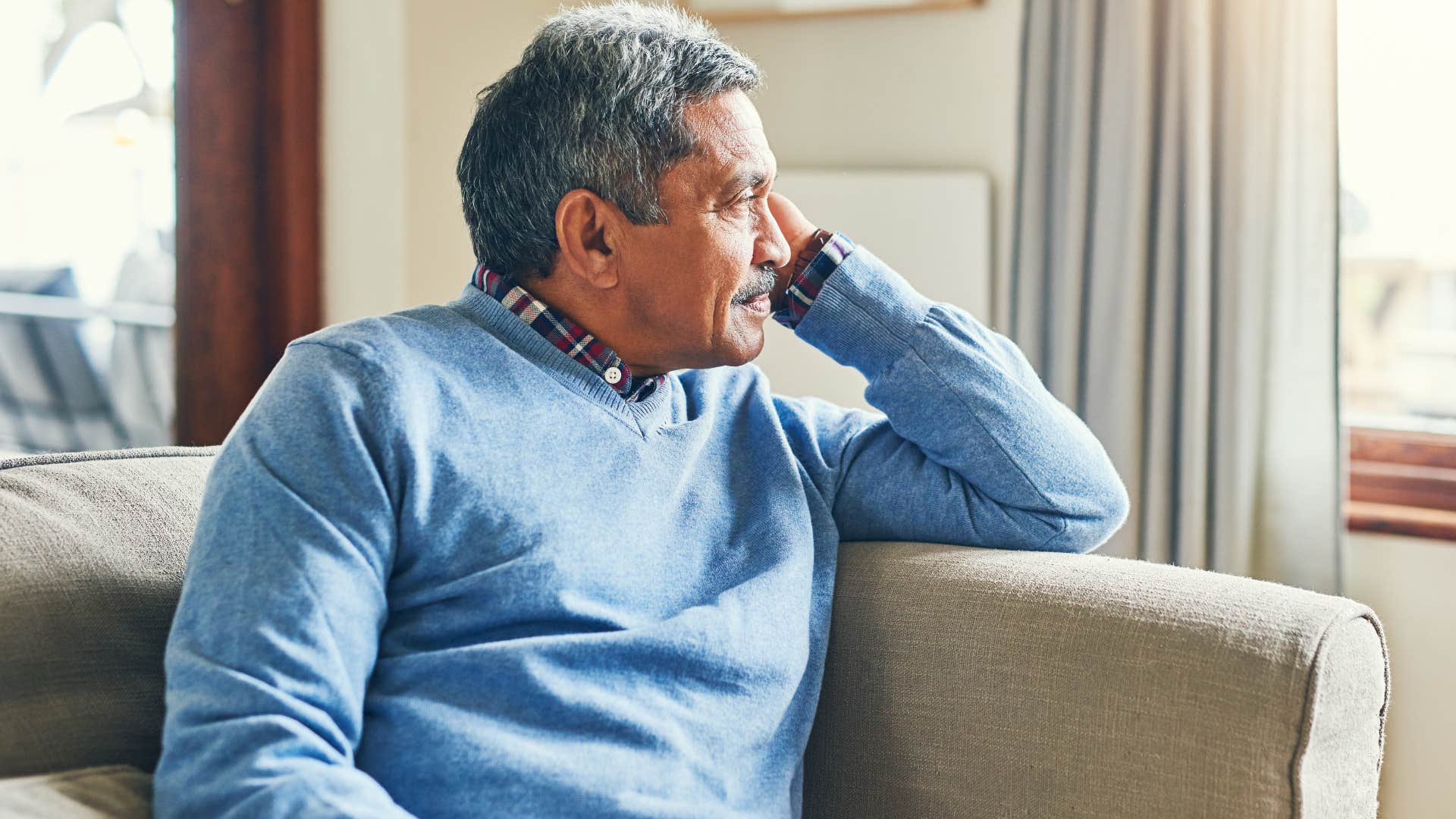 sad lonely man sitting alone on couch