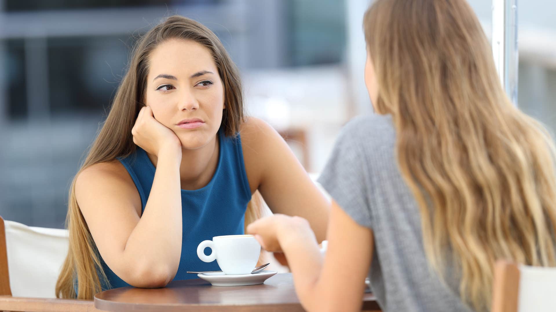 annoyed woman listening to friend talk incessantly