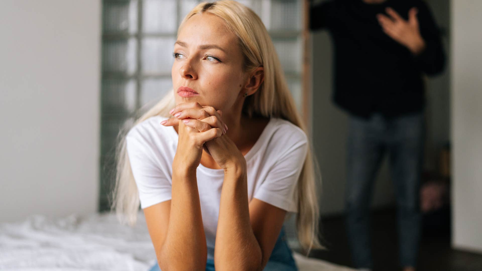 emotionally withdrawn woman sitting on bed