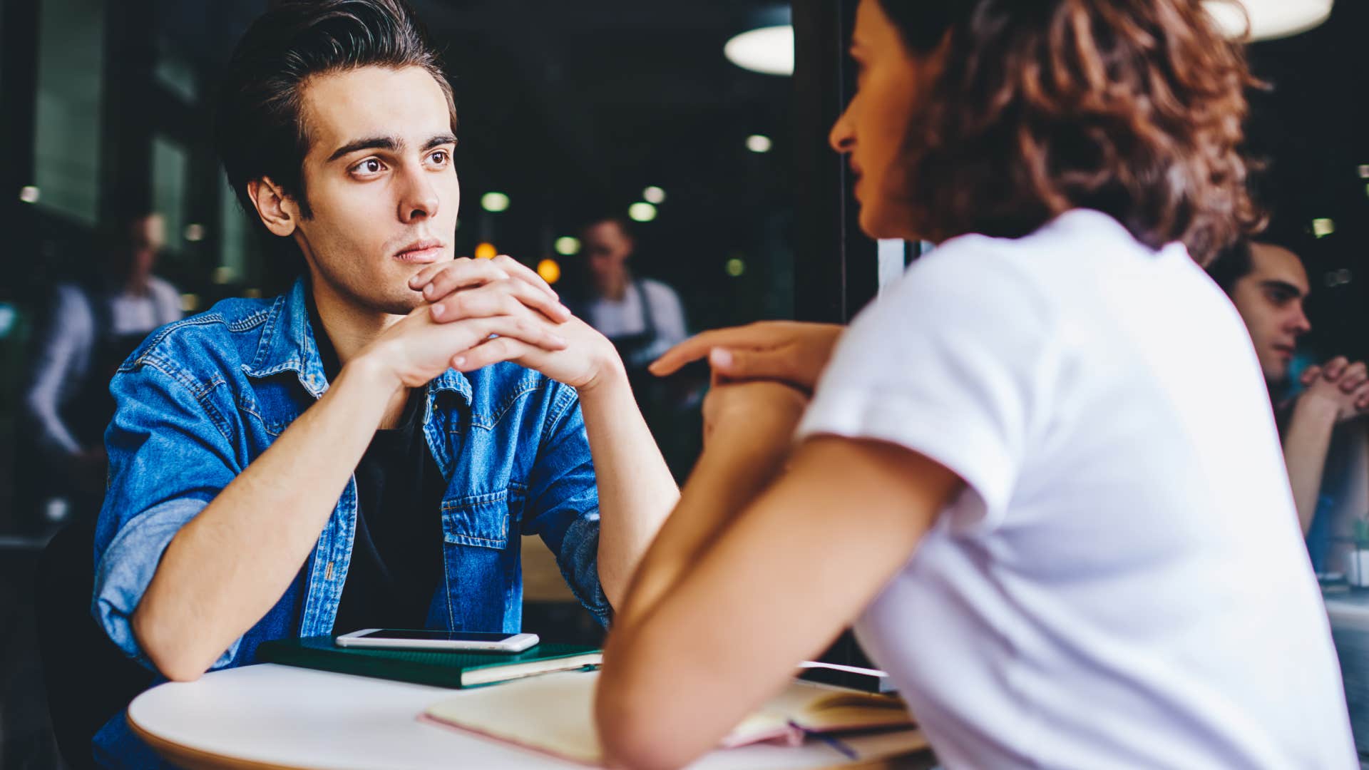 young man Appearing disinterested listening to woman at restaurant