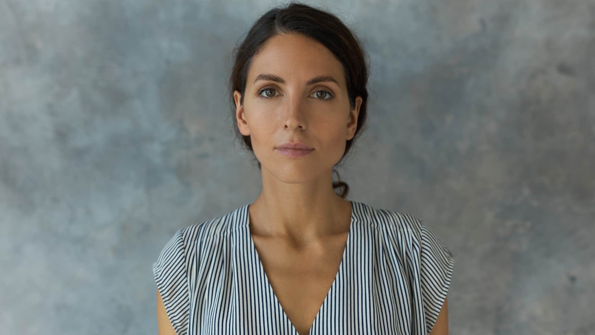 woman with neutral facial expression against background