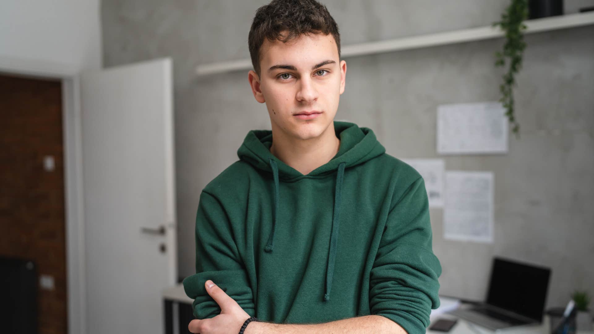 young man standing in room slow to make decisions