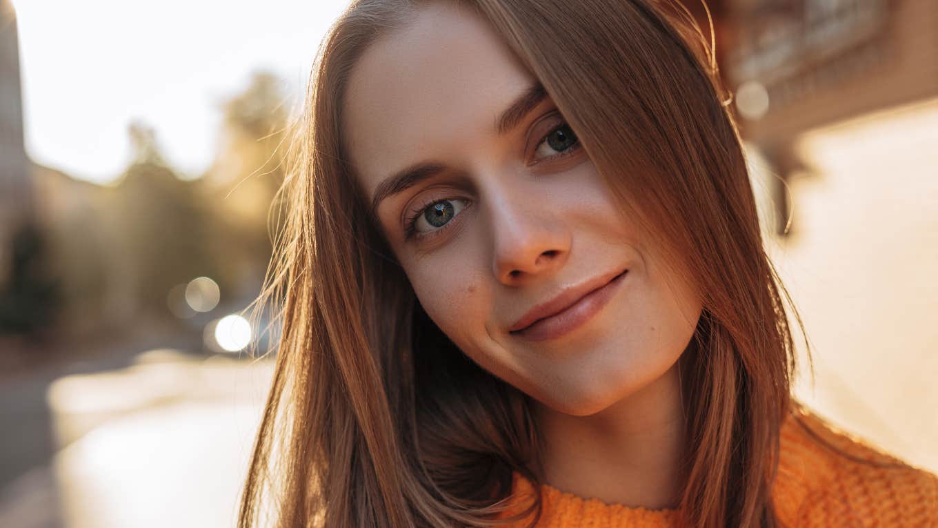 introverted woman with red hair looking at camera