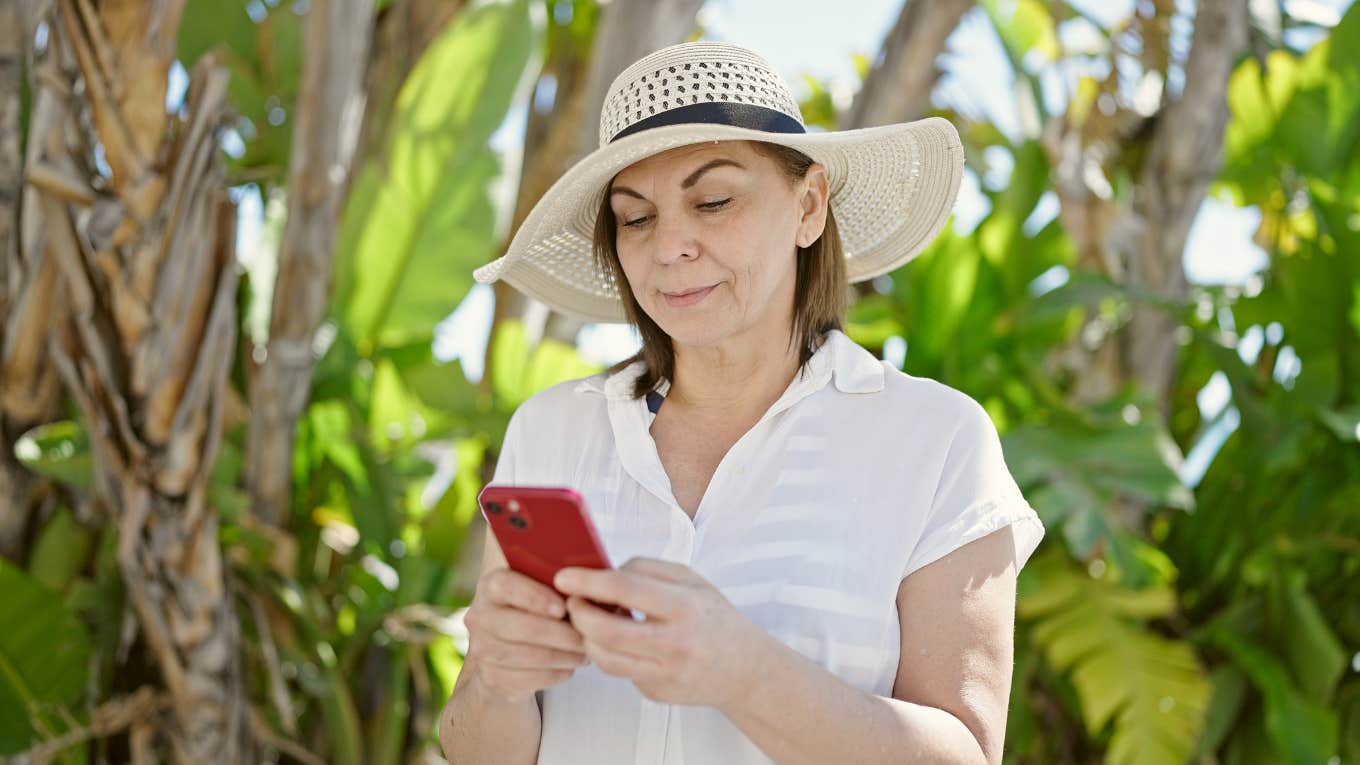 Mom getting a text from her son's boss while they are on vacation together