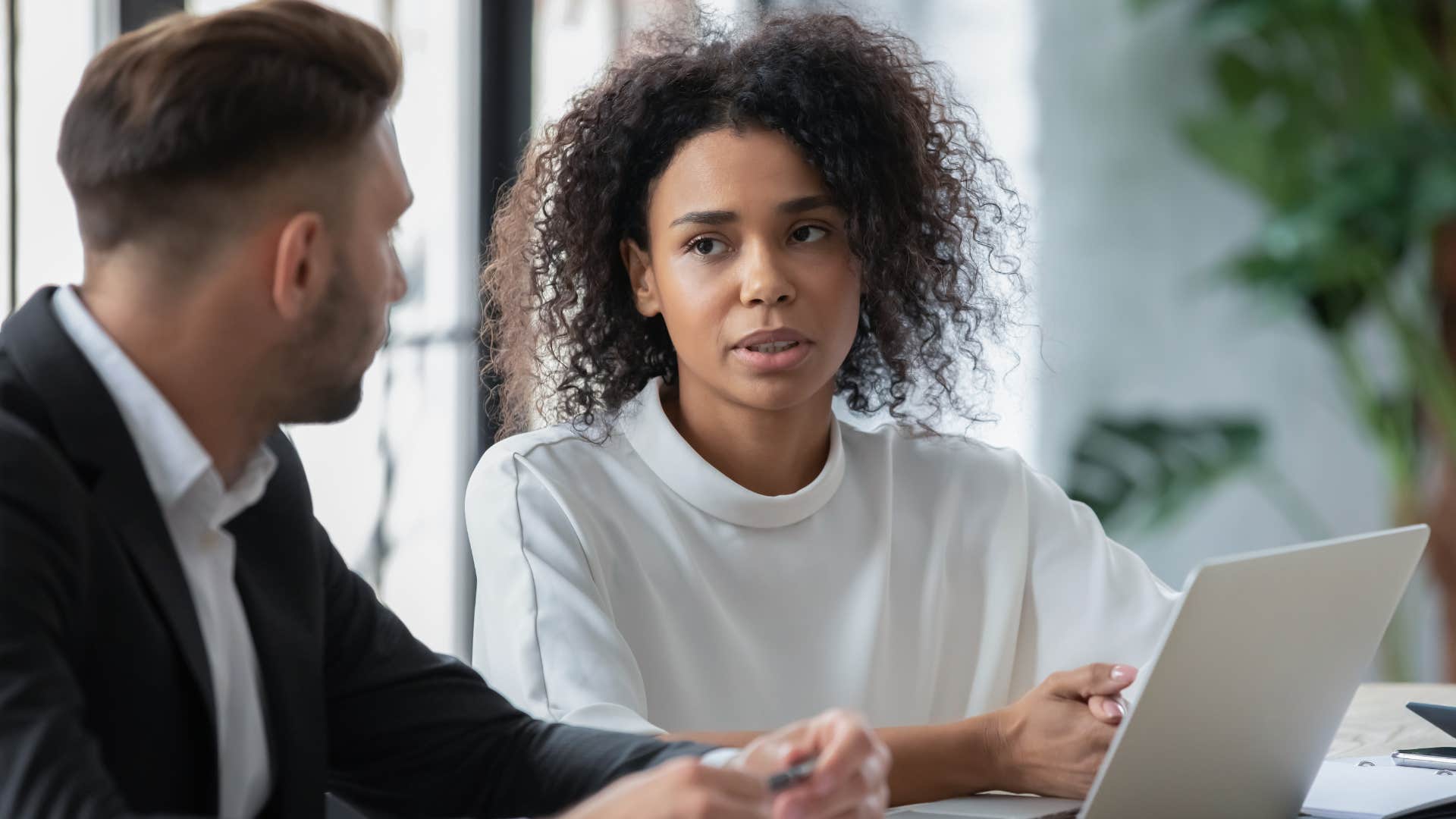 serious woman speaking with male colleague