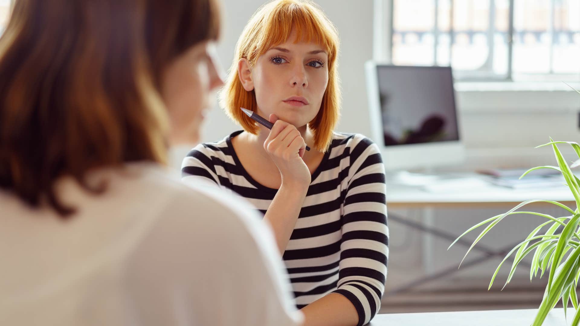 serious woman listening to colleague speak