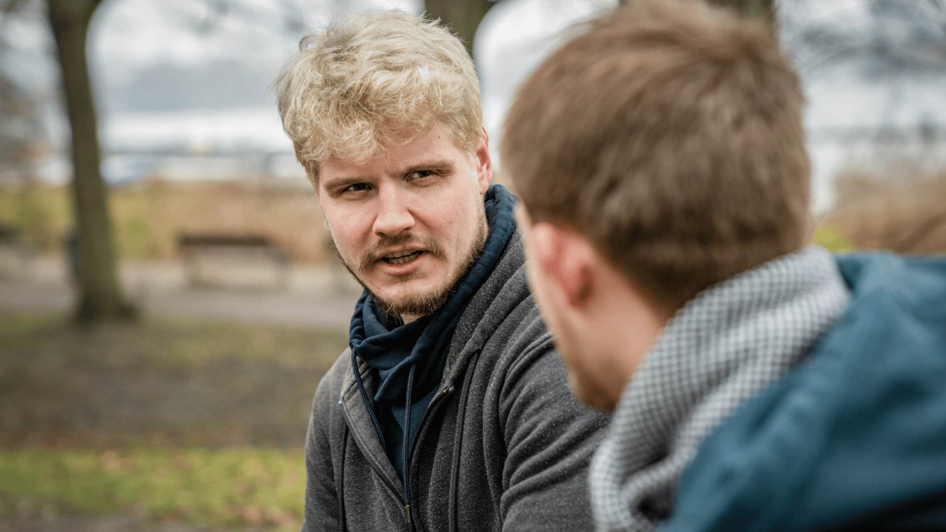 two men talking outside