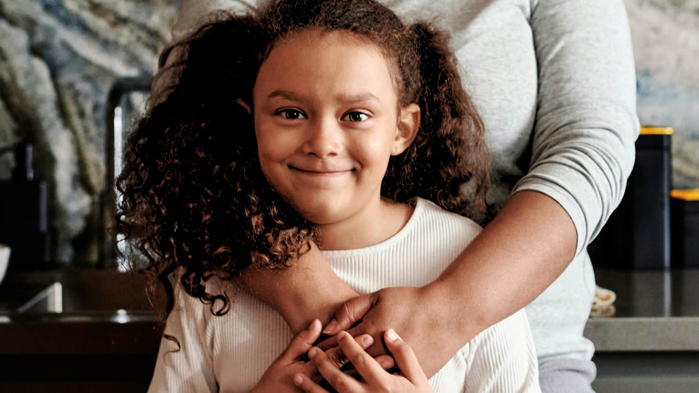 Child raised well, embraced by her mother's arms.