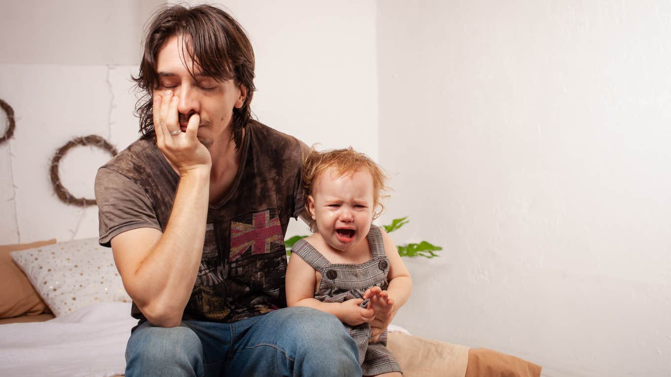 stressed dad holding crying baby