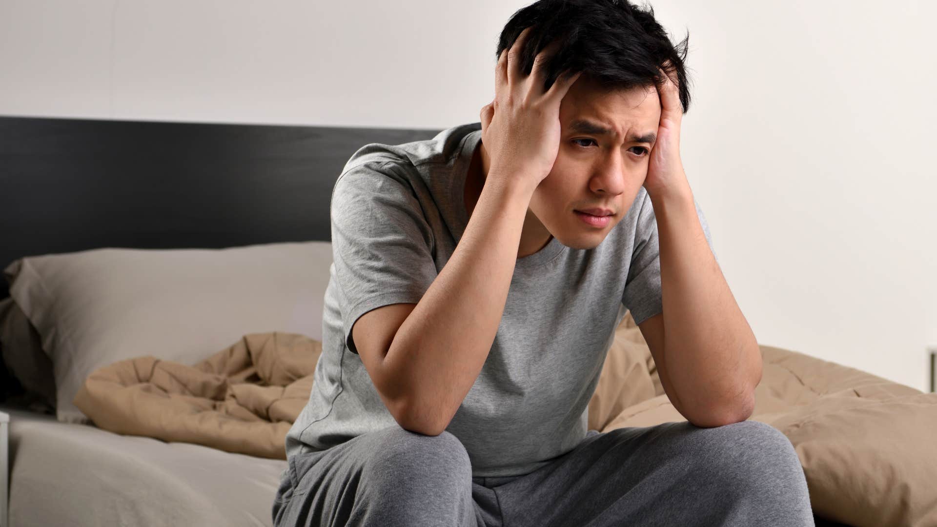 stressed man holding his head in his hands