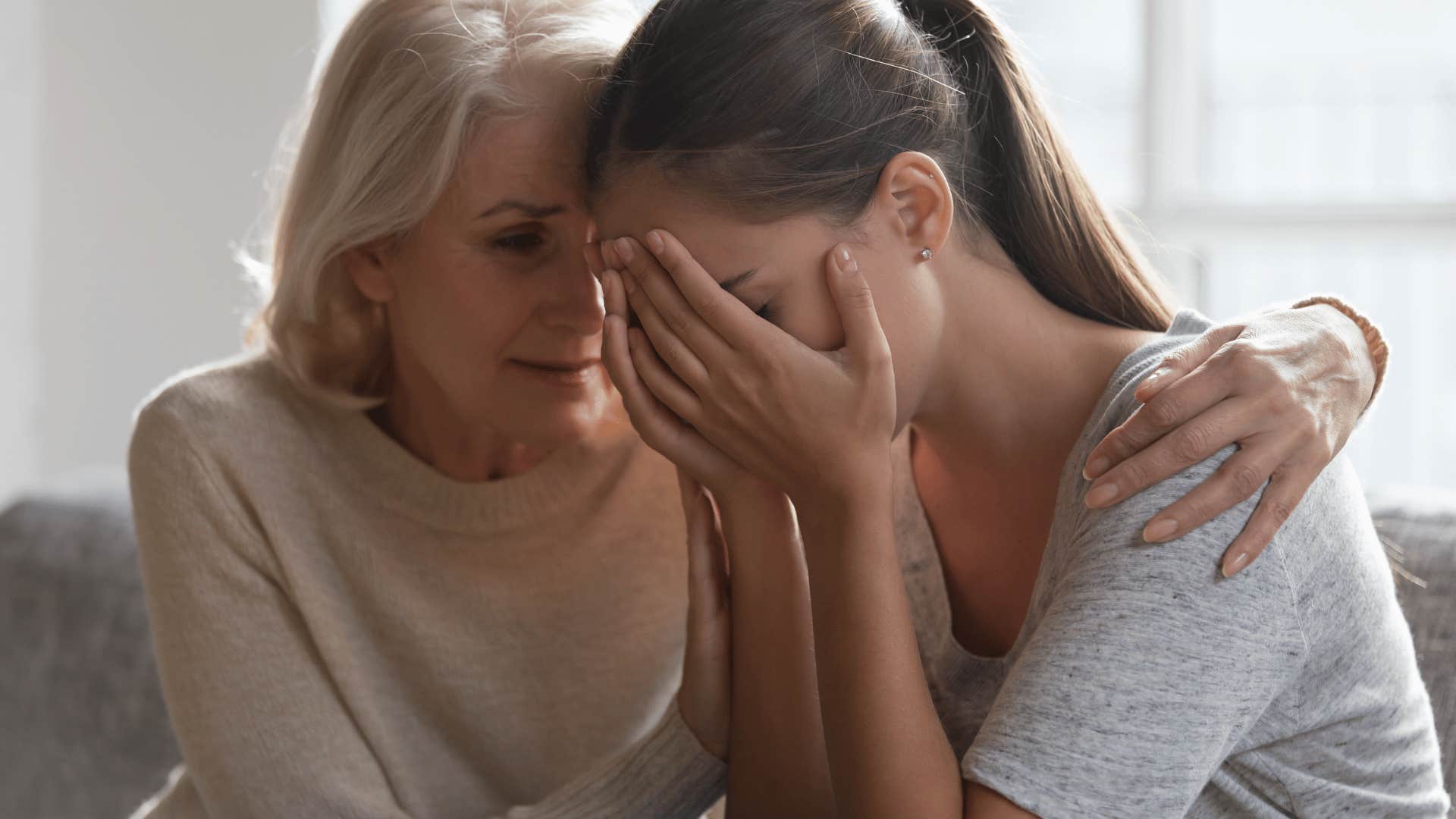 mother comforting adult daughter