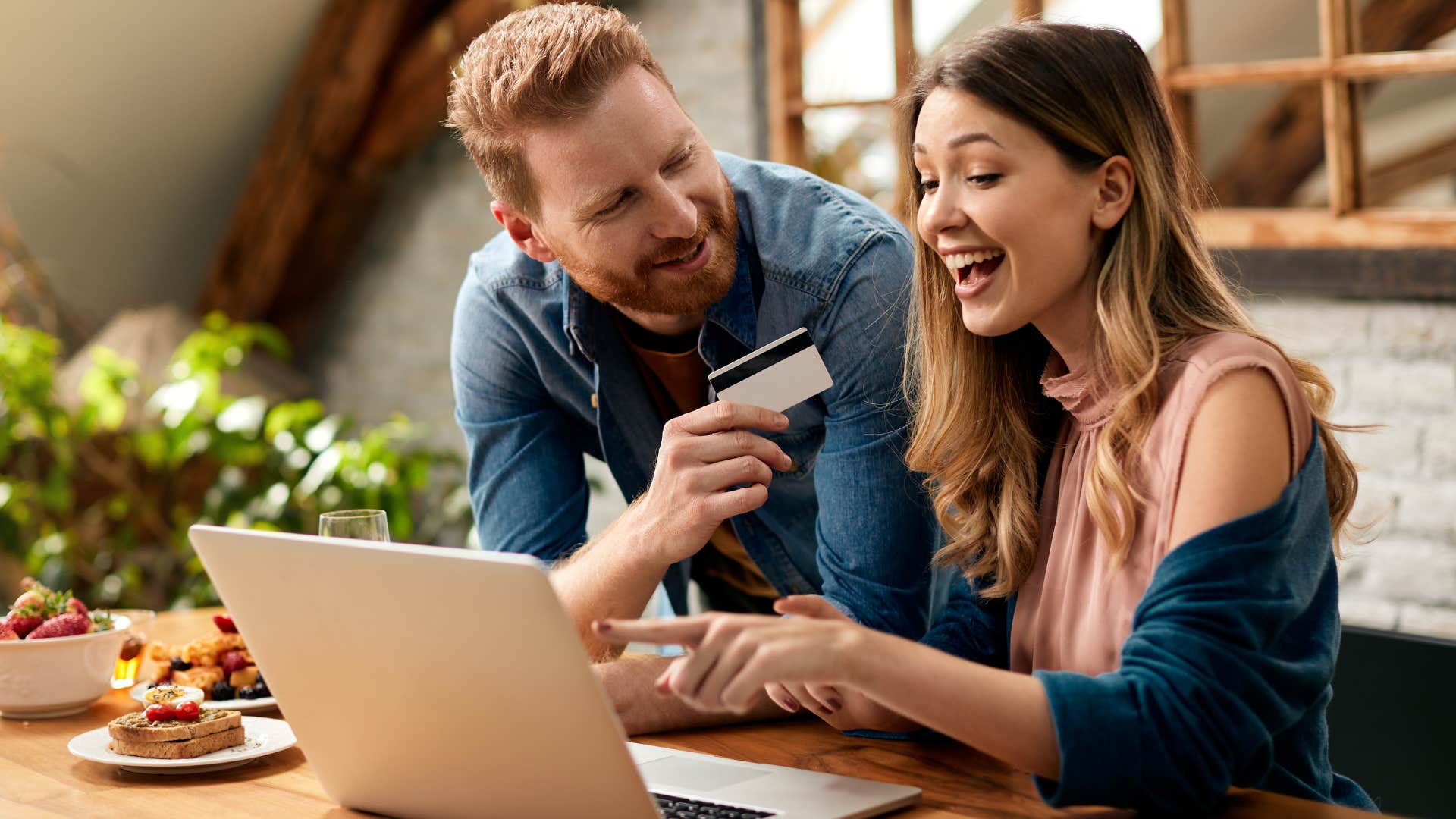 Gen Z couple smiling and paying a bill online