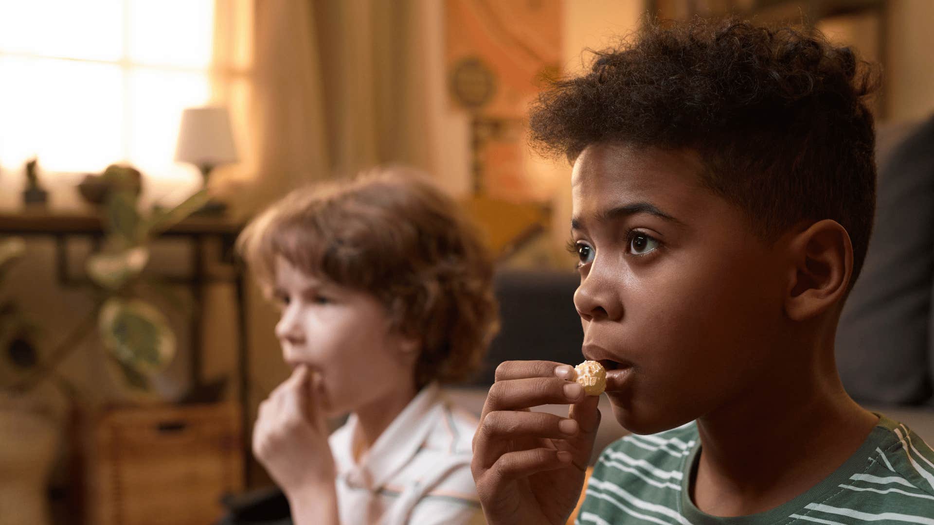 Two boys are fascinated watching TV