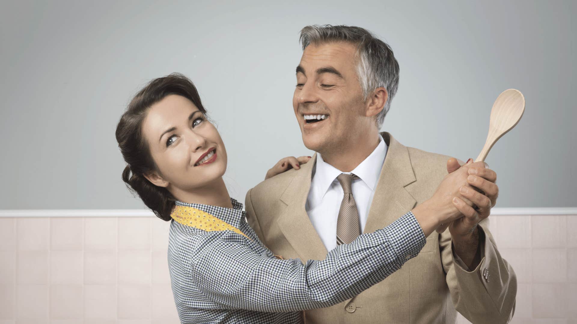 Vintage looking parents dance with wooden spoon