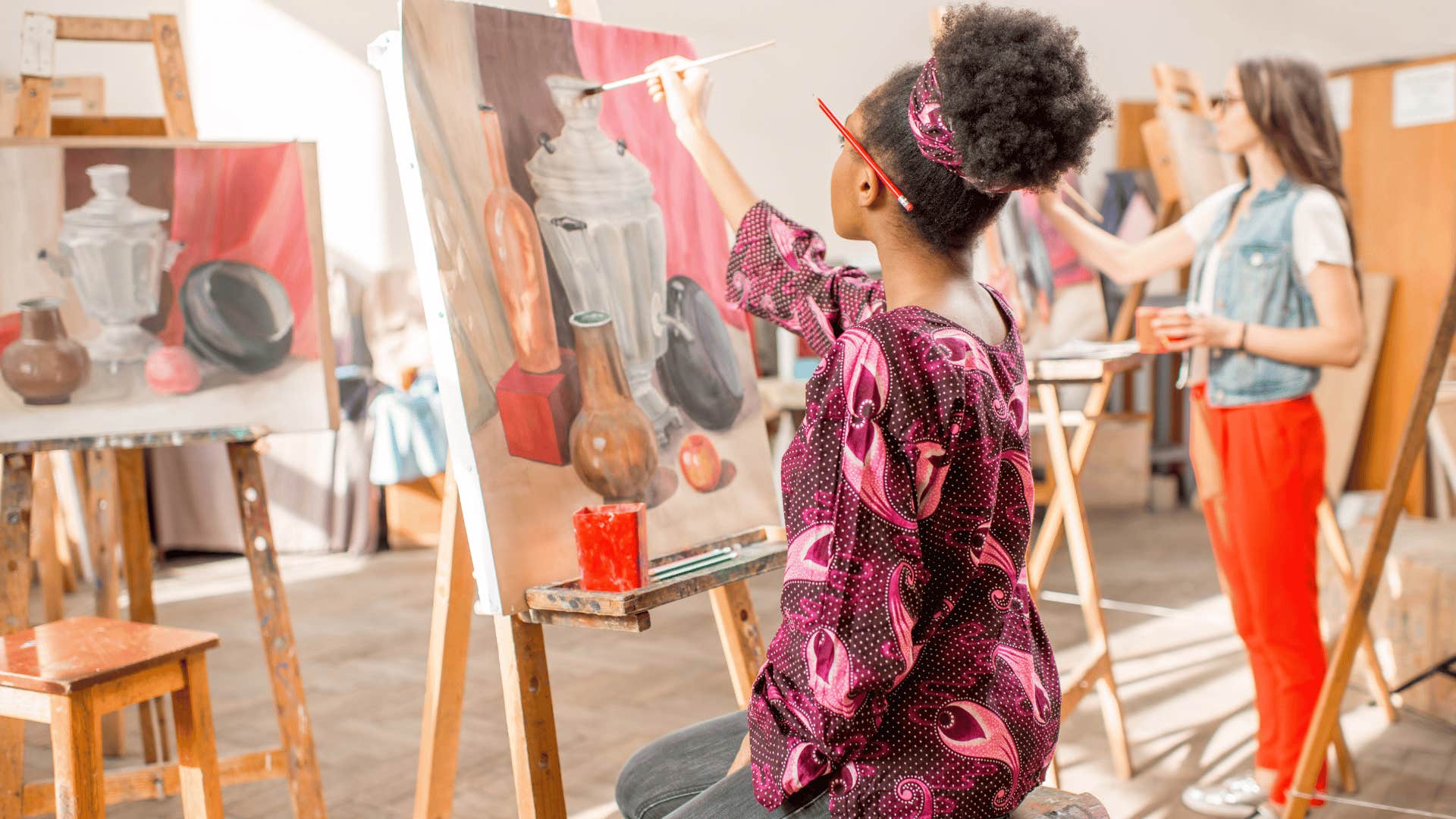 young woman painting in studio