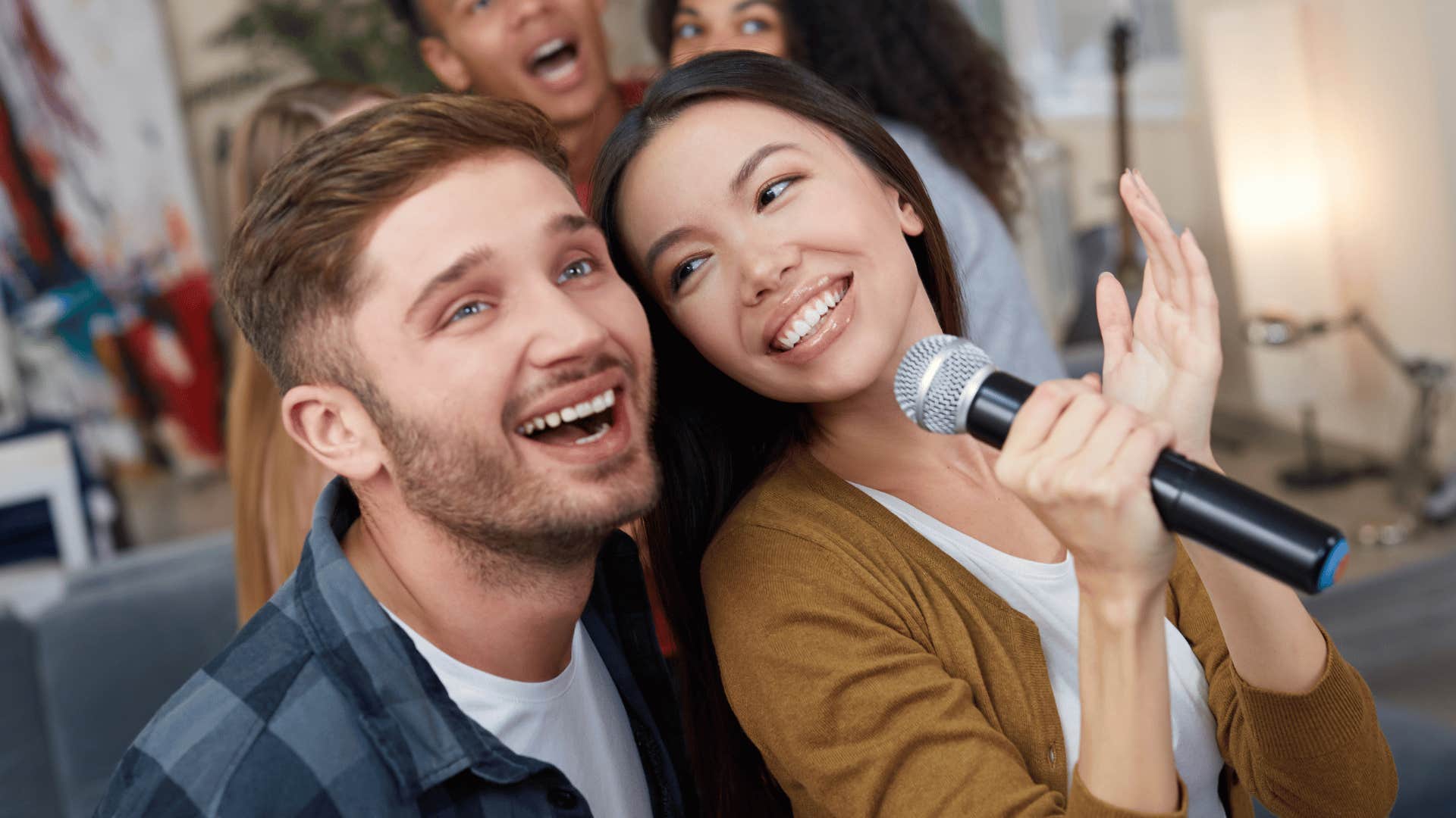 gen z couple singing on microphone