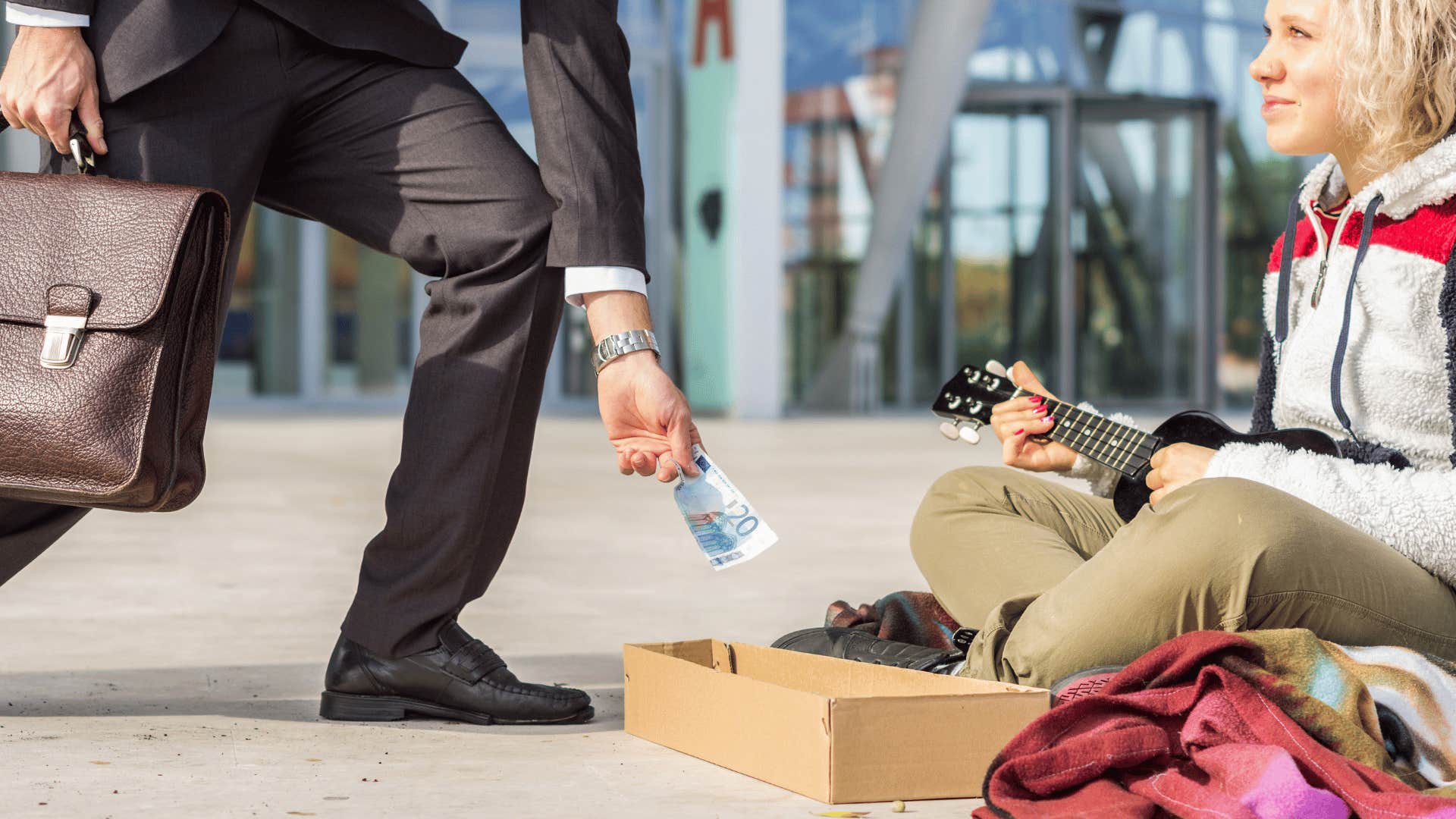 man giving homeless woman money