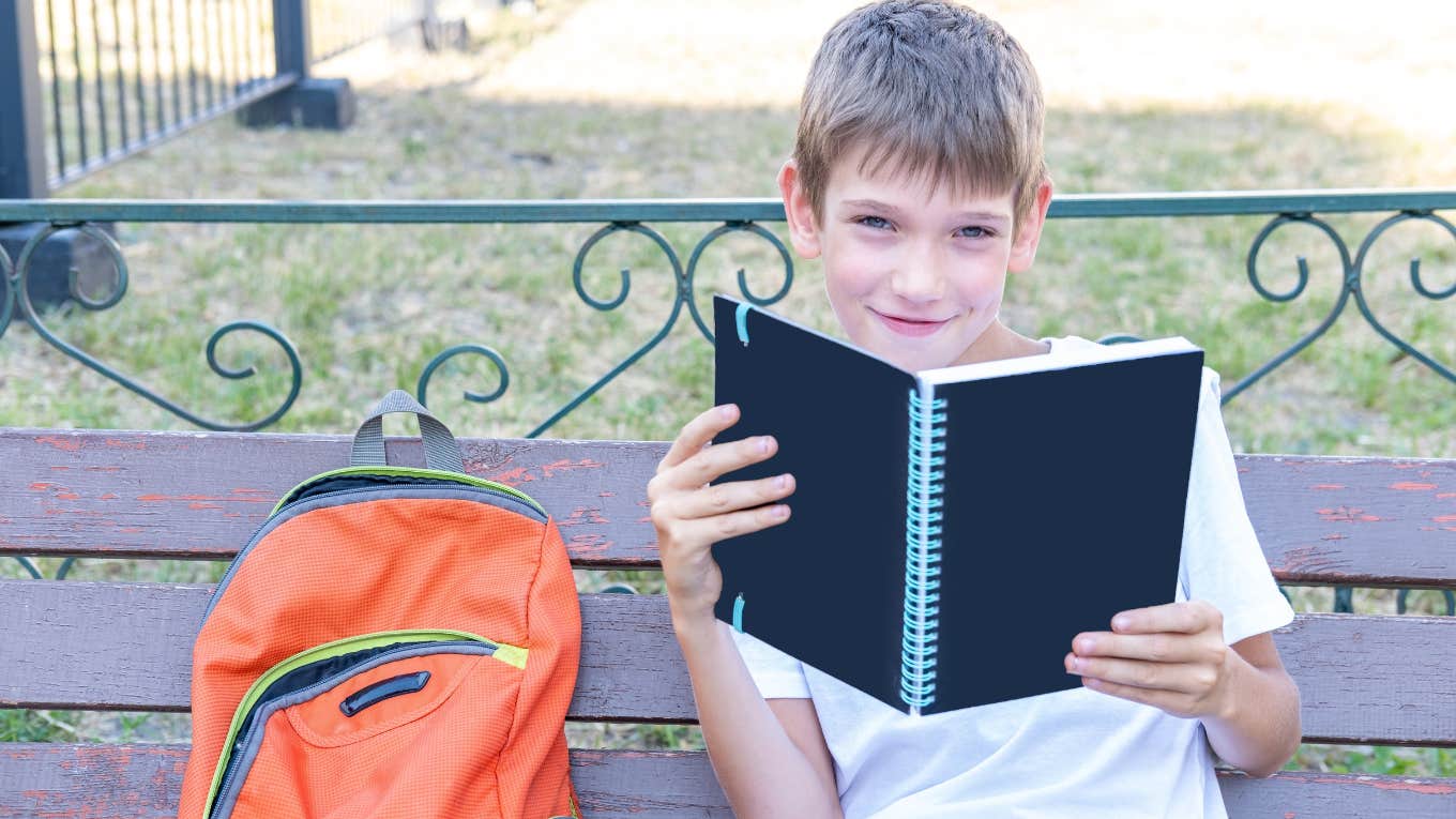 Young boy sitting on a buddy bench at school because he wants to make friends