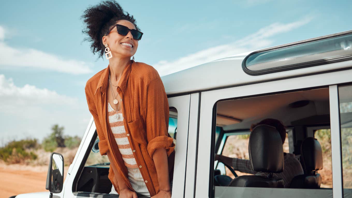 woman leaning out car window on holiday trip