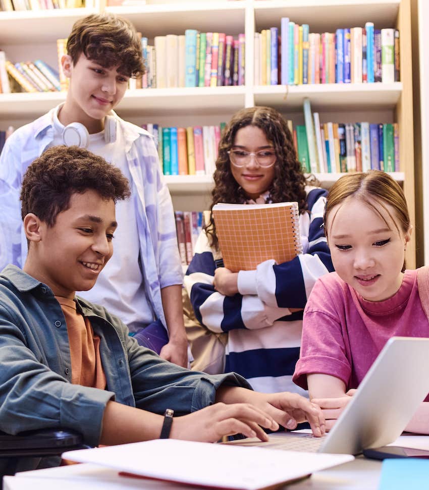 Teenagers study together in school library