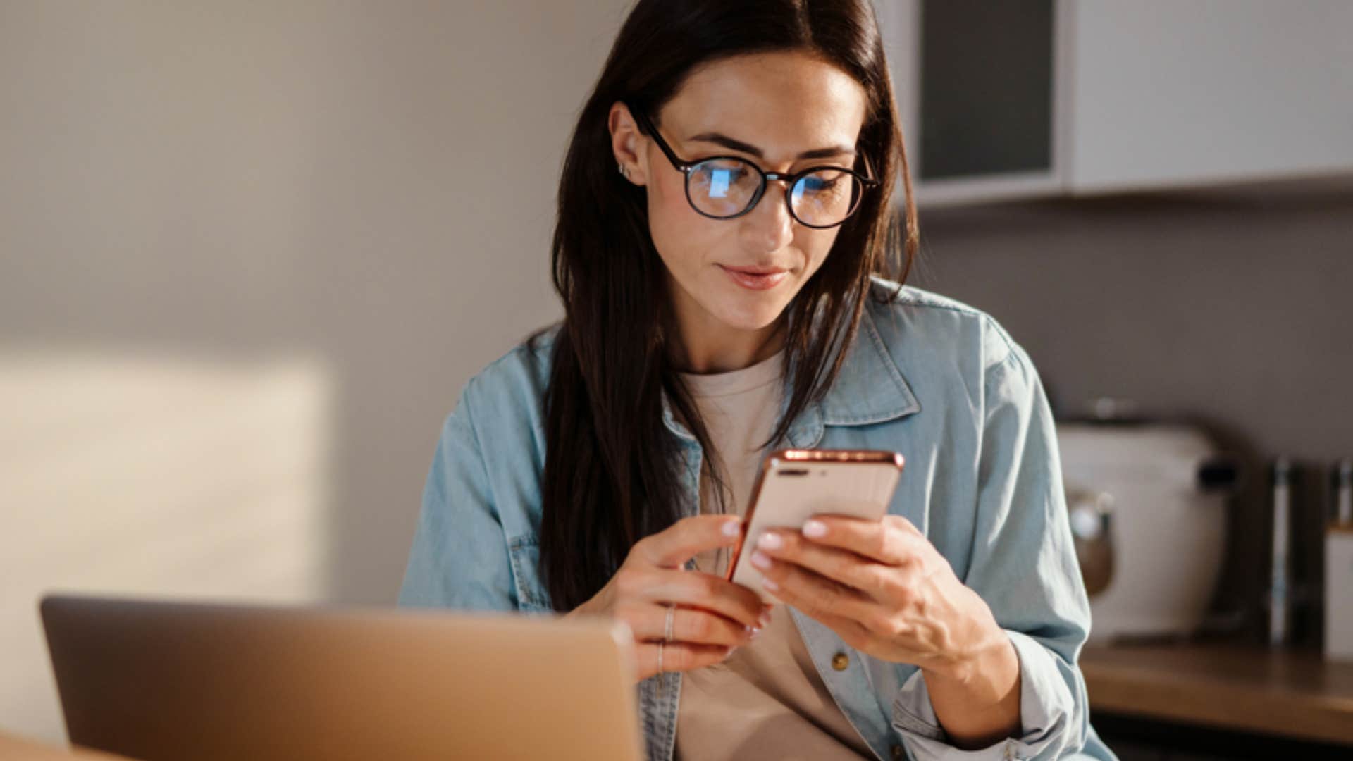 millennial woman using phone at work