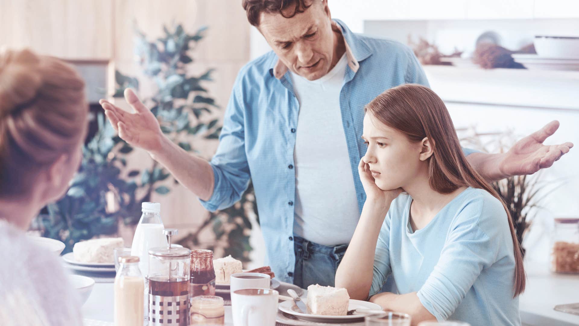 dad yelling at daughter at table