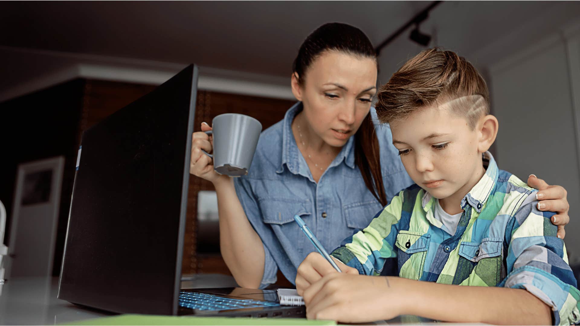 woman watching son do homework