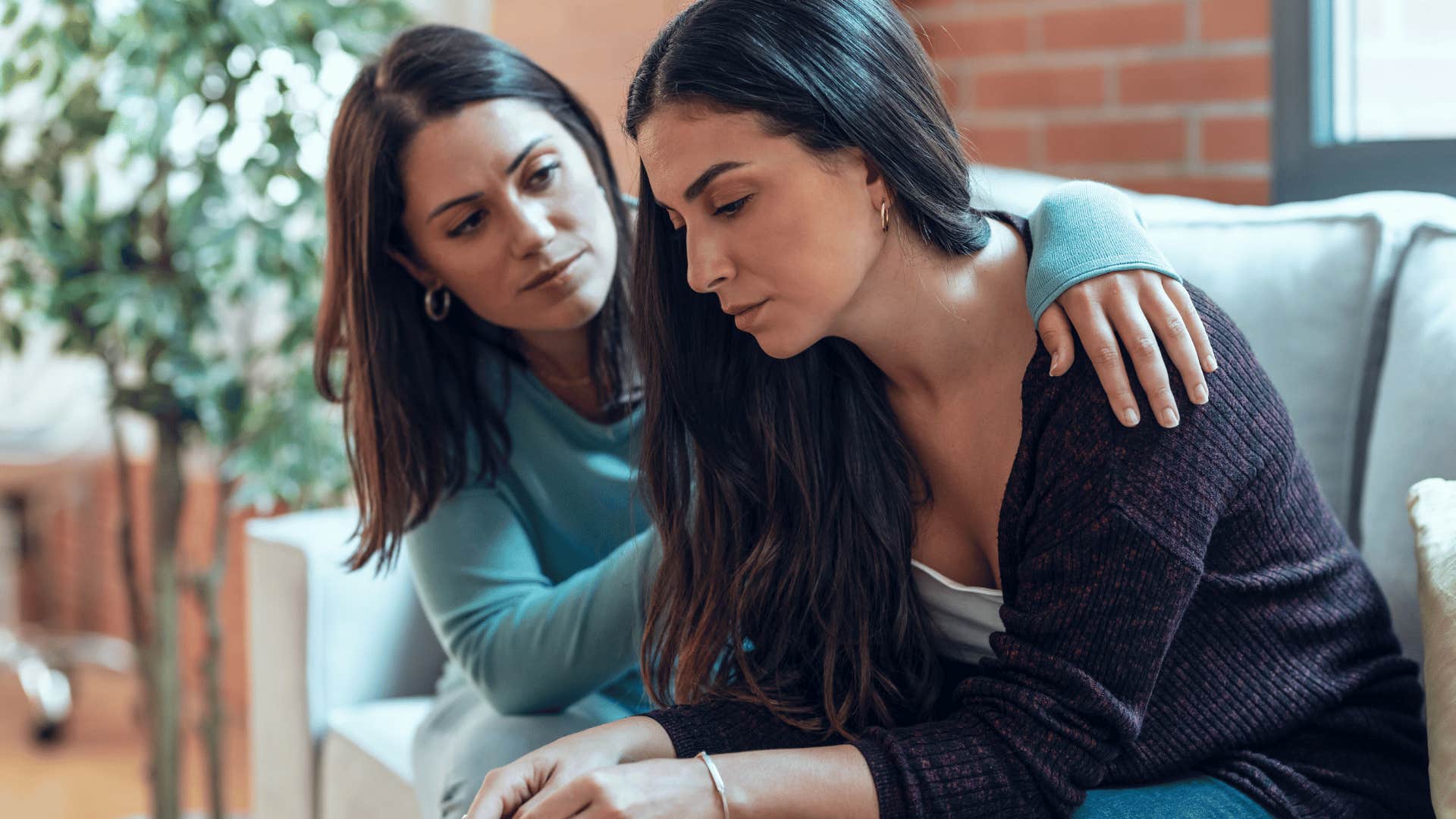 woman comforting friend on couch