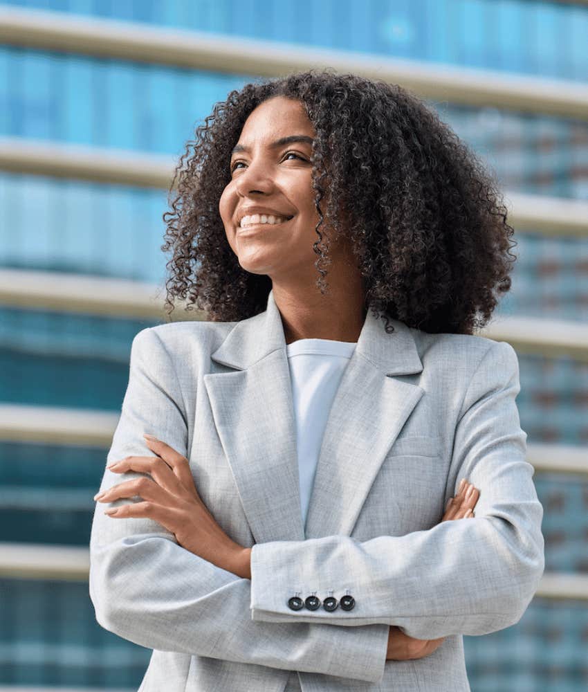 Rich Millennial smiles outside office building