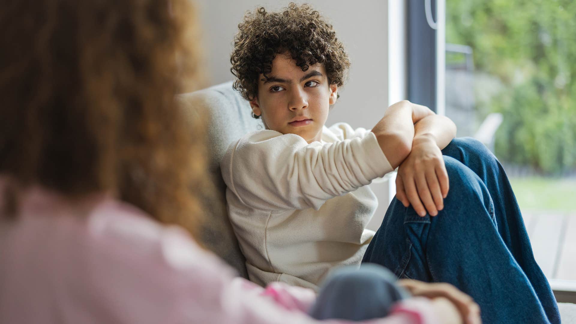 Upset young boy looking at his mom