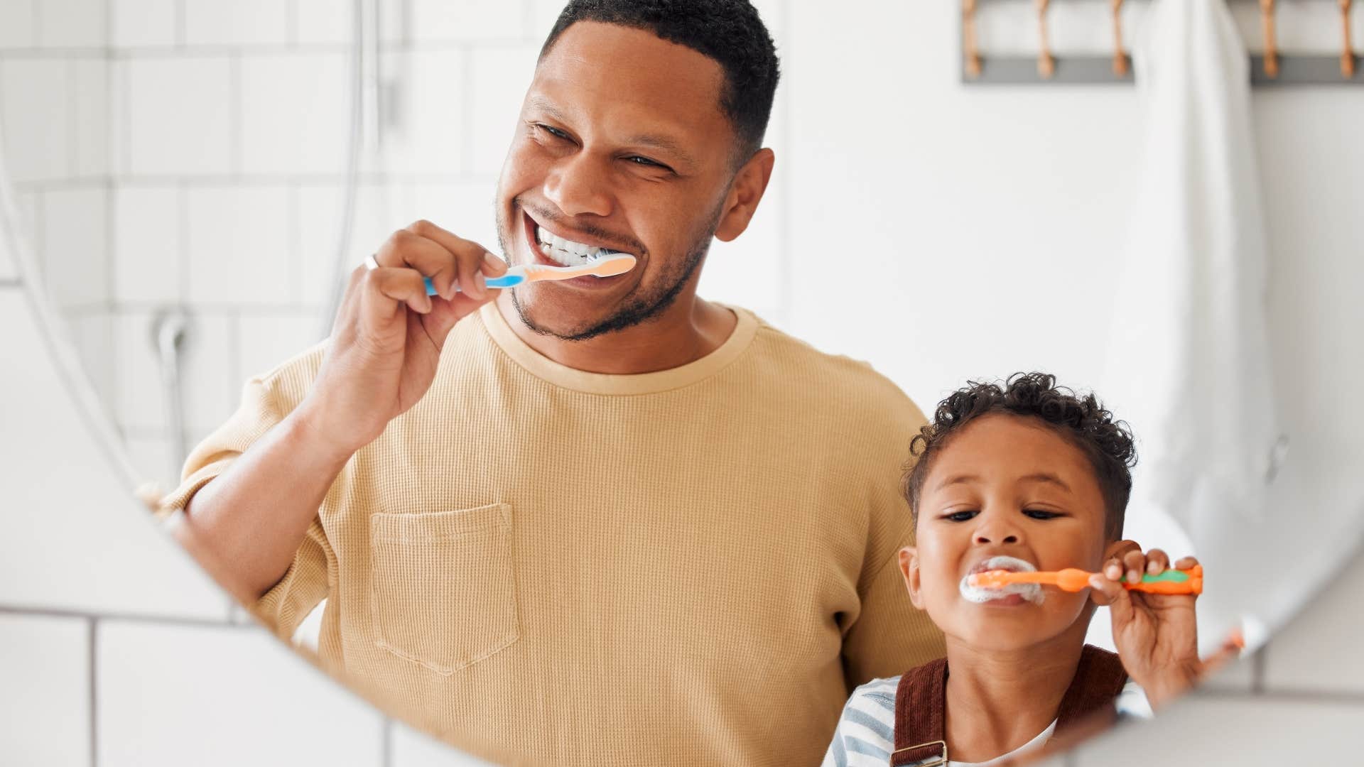 Dad and son brushing their teeth during consistent routine