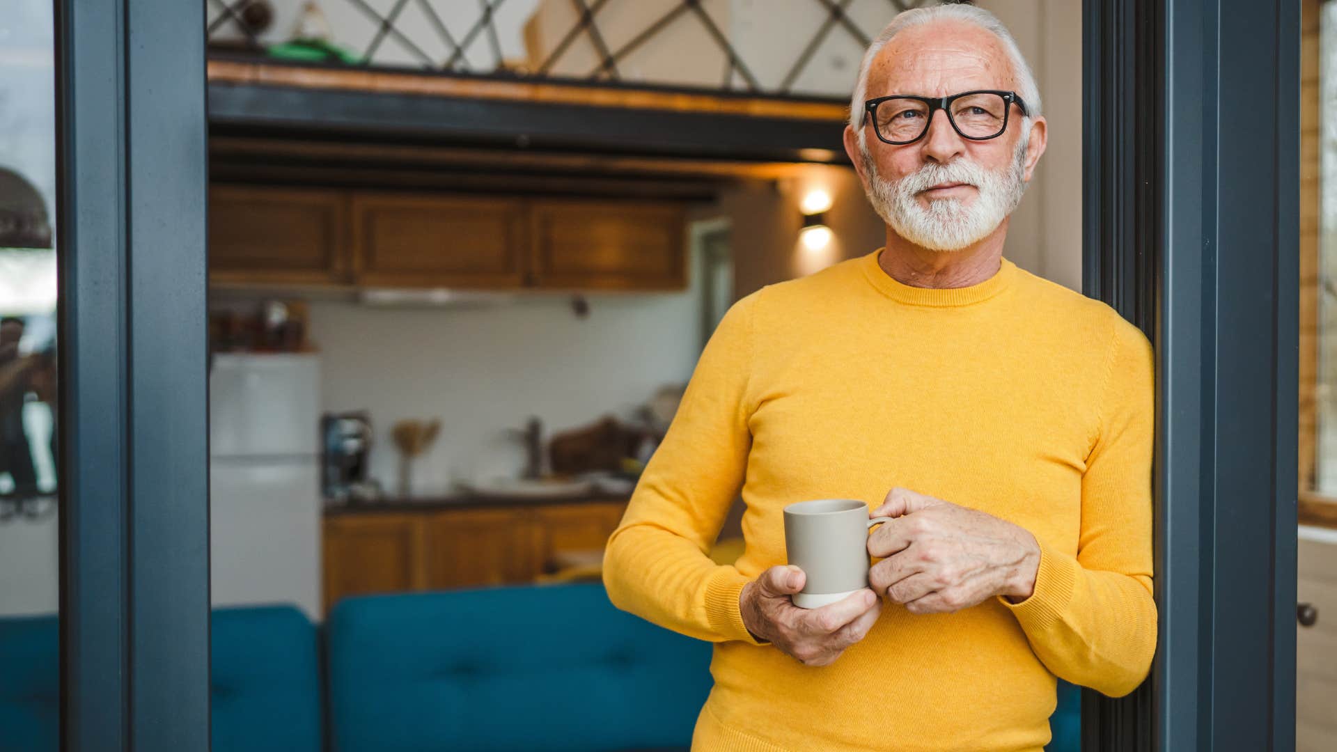 Older man smiling and holding a mug of coffee