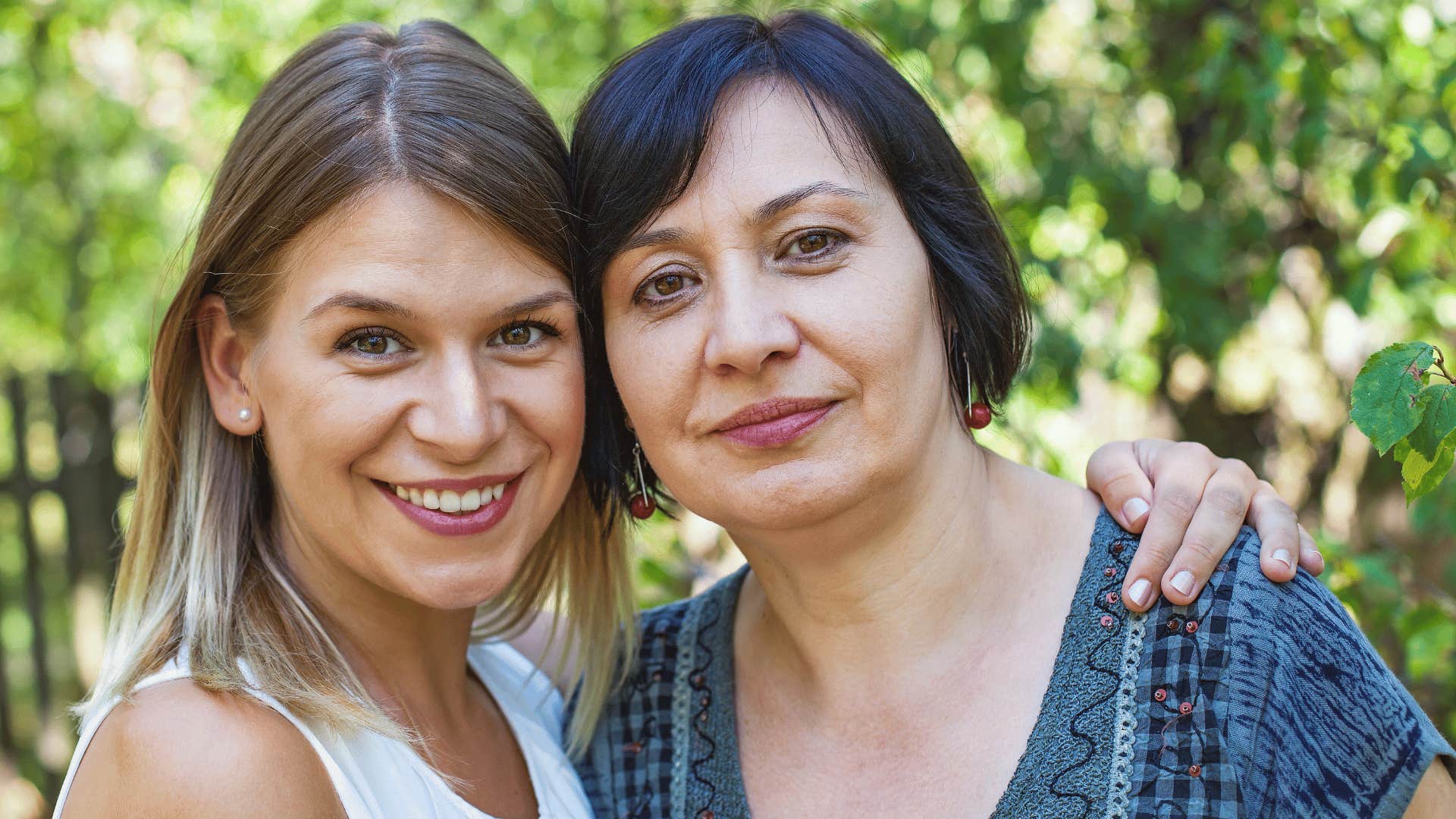 Adult daughter smiles with serious mother