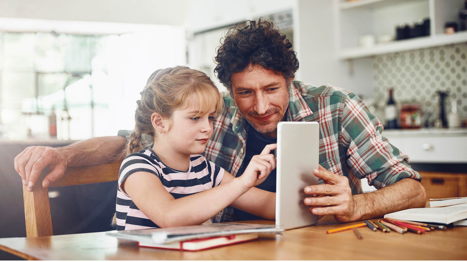 dad with daughter looking at tablet