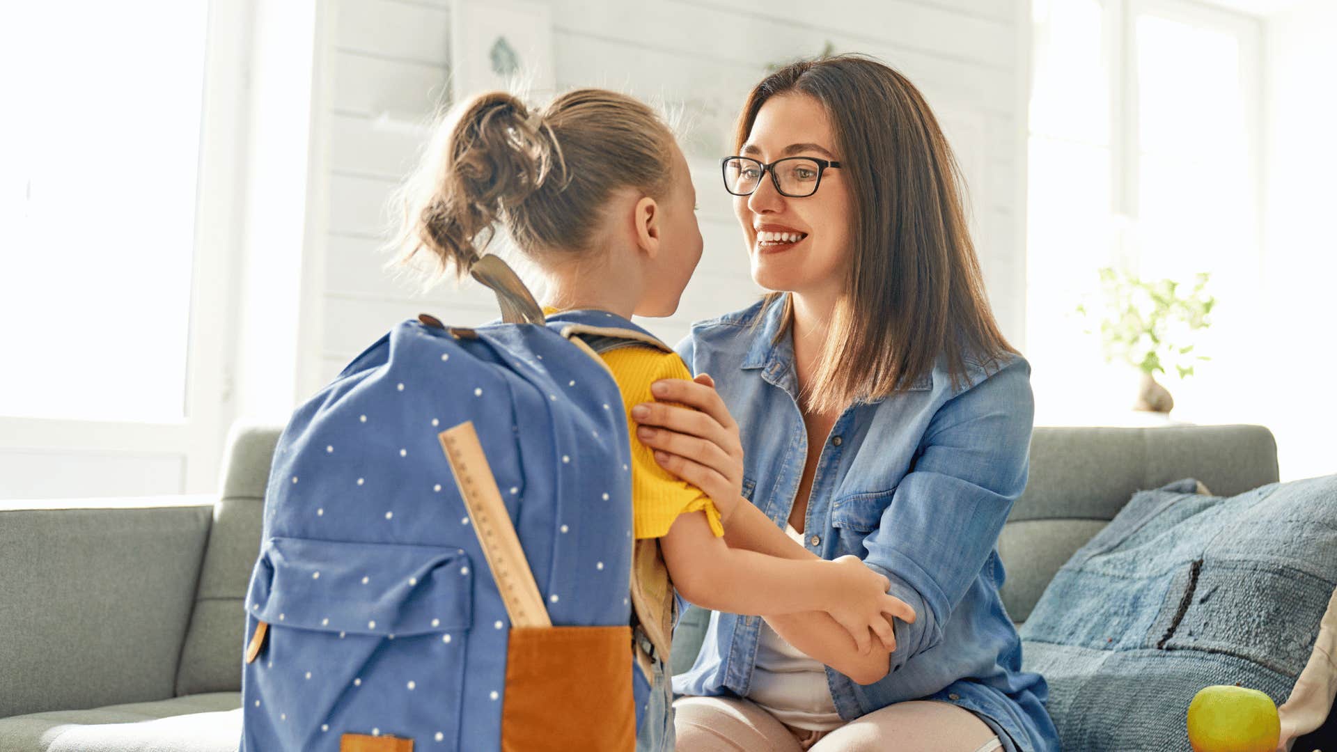 mother talking to child with backpack