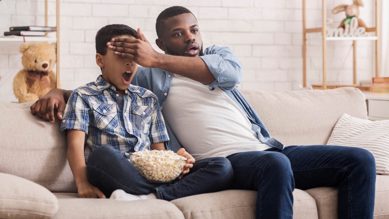 Dad blocking his kid's eyes from seeing a movie