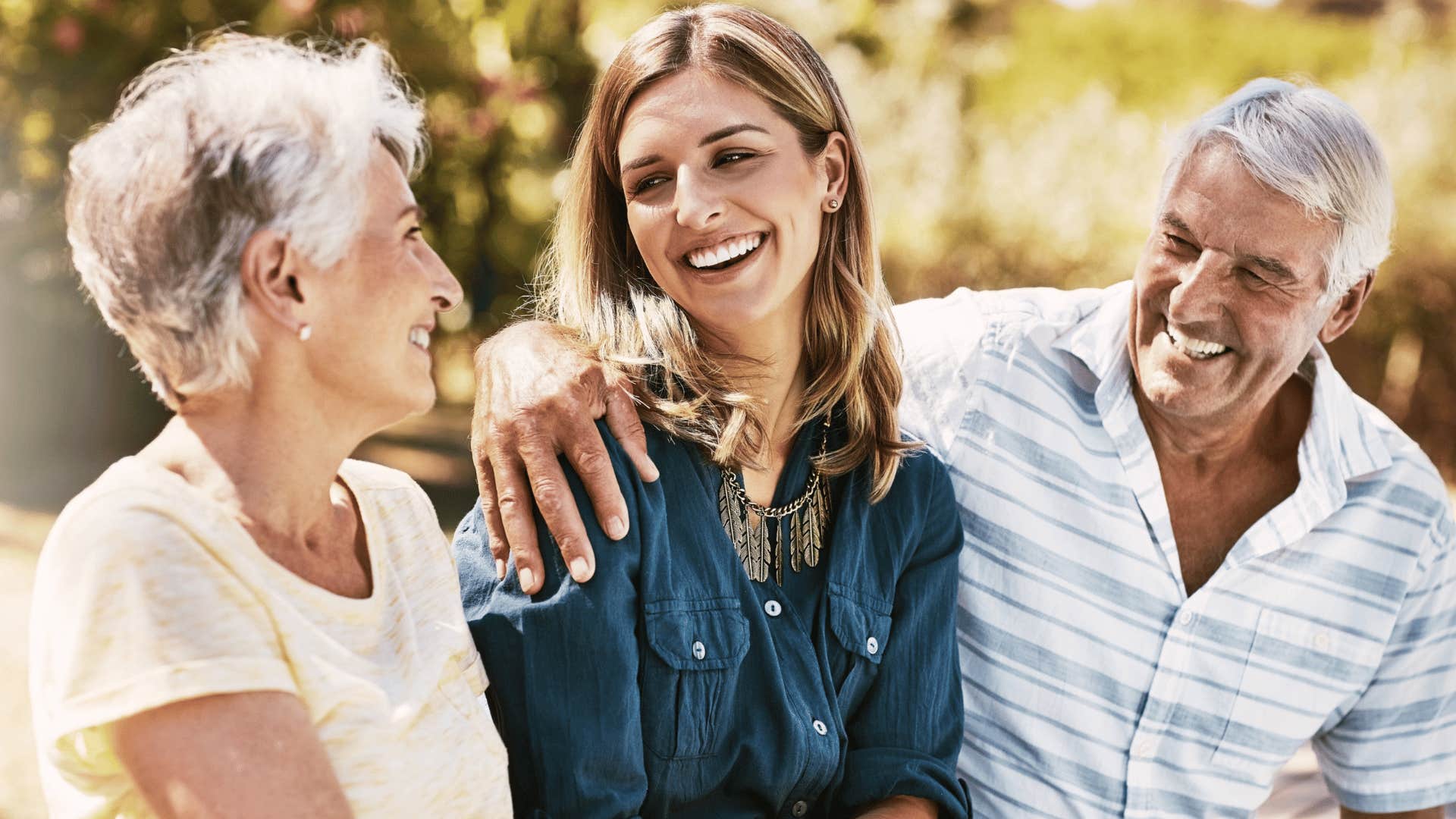 two parents smiling with pride at adult daughter