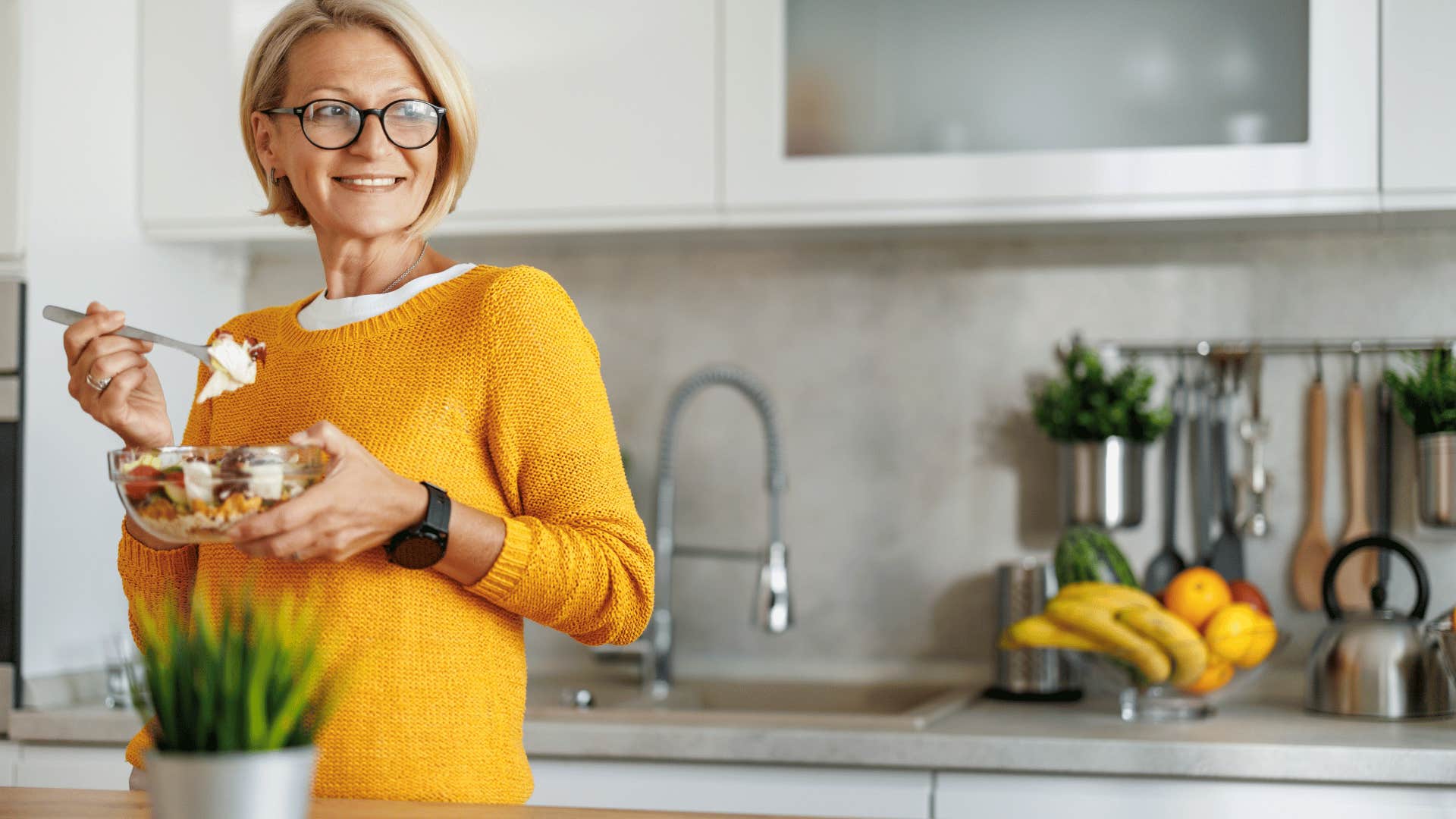 woman eating healthy in kitchen