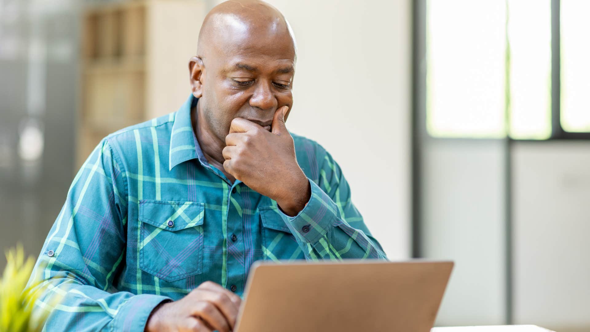 older man working intently on his laptop