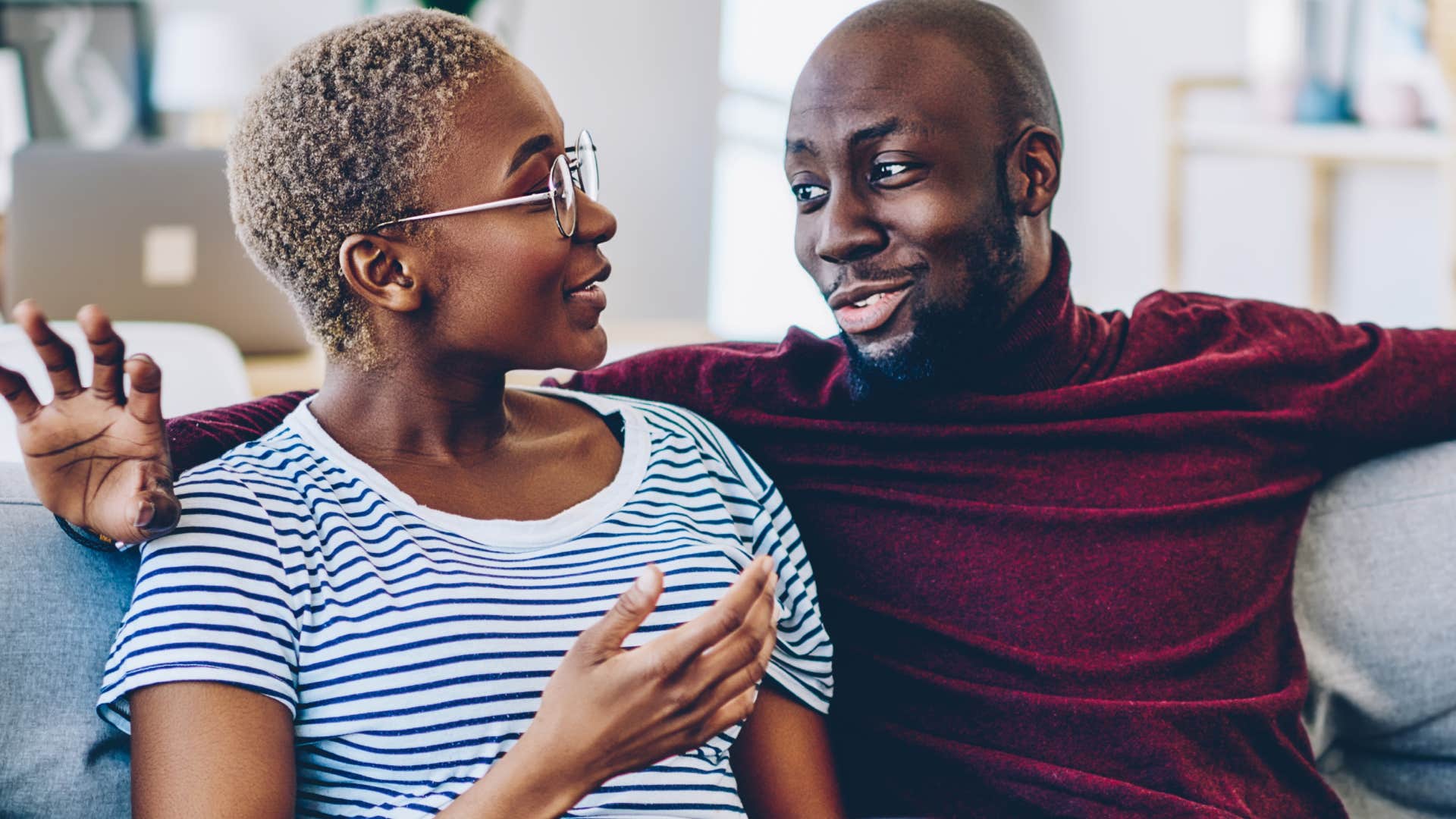 couple having conversation sitting on couch together