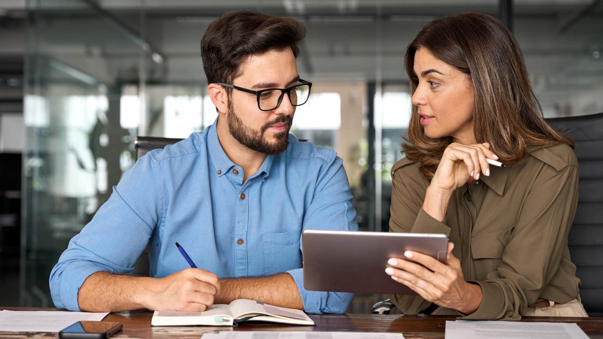 Professional woman having a serious conversation with a man at work.