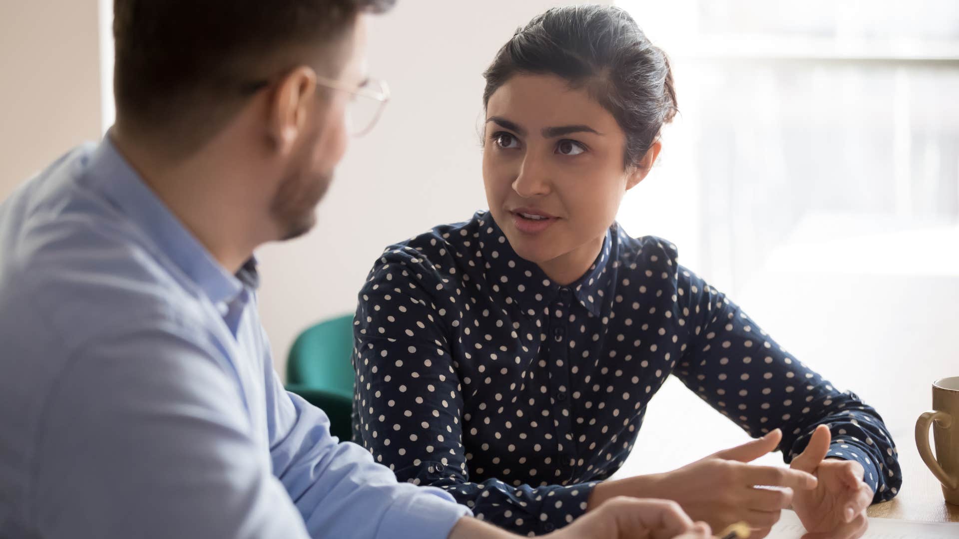 Young woman having a serious discussion with a man at work