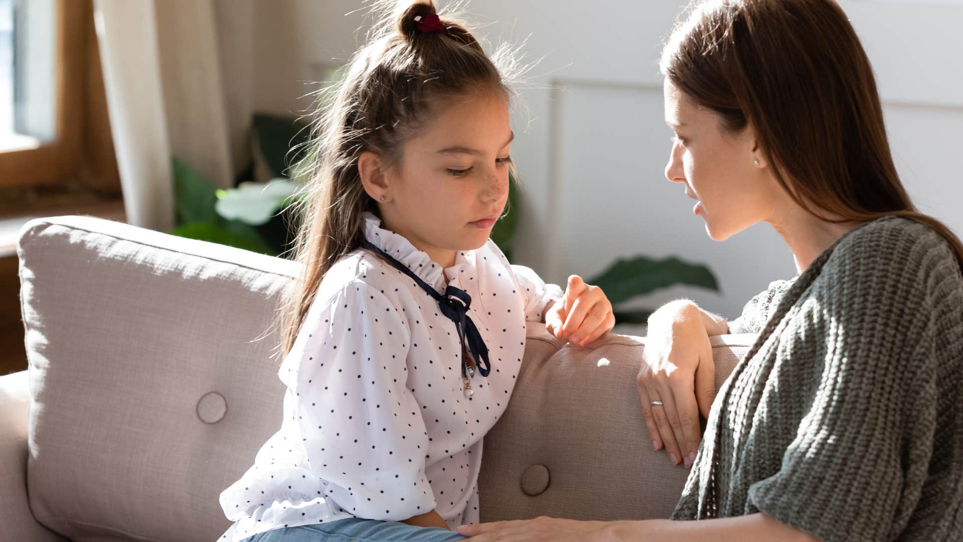 woman having serious conversation with young daughter