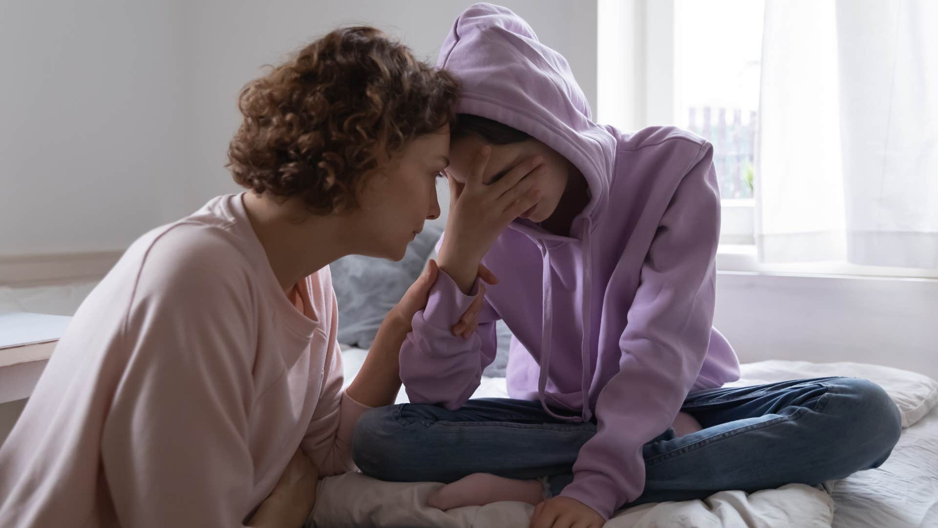 woman comforting upset teenage daughter